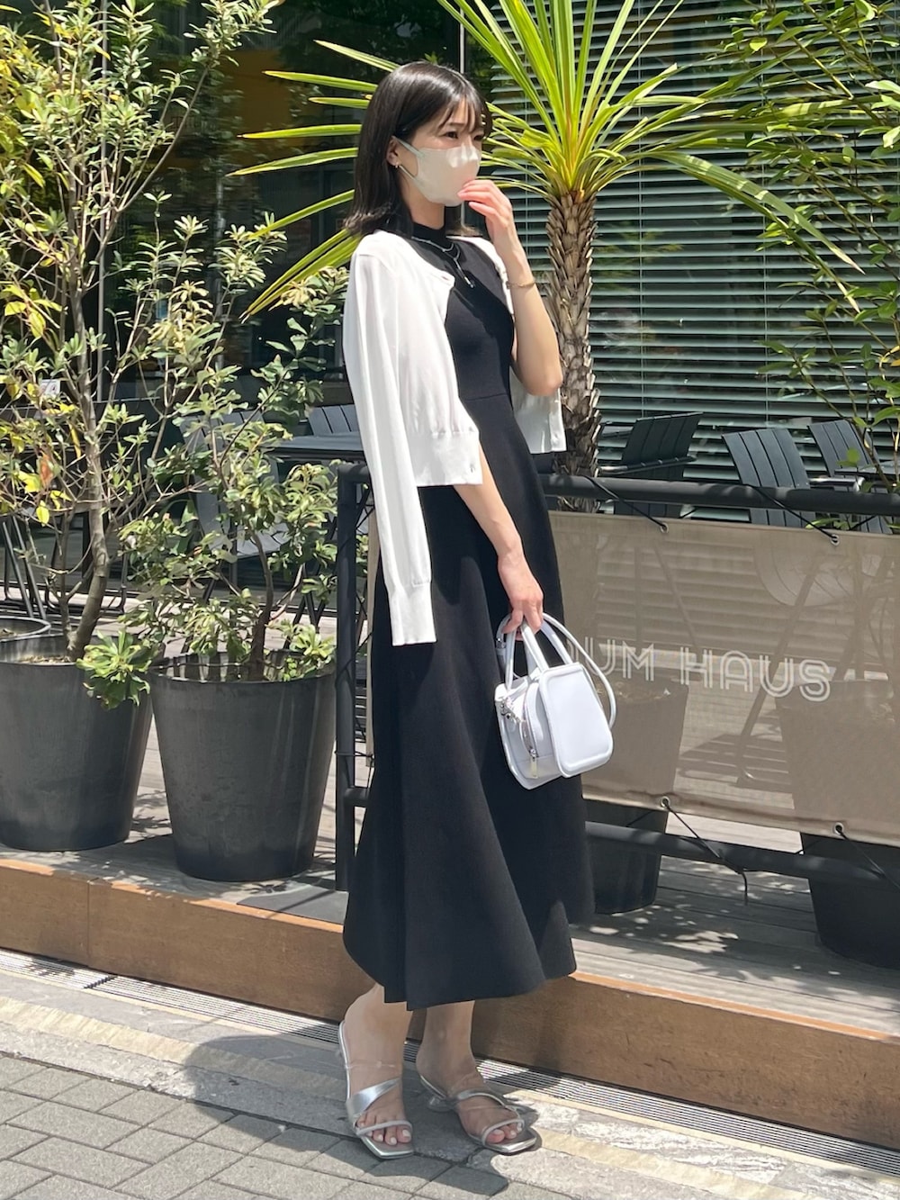 ブラック系のワンピース、ホワイト系のカーディガン/ボレロ、ブルー系のハンドバッグを着用したレディースの春コーディネートの8枚目の写真