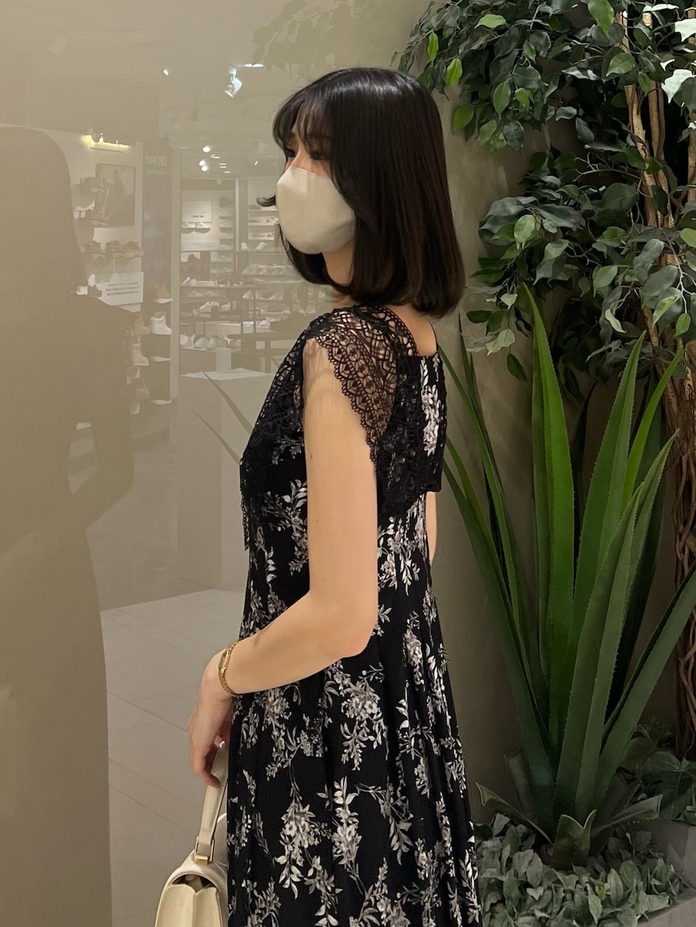 ホワイト系のハンドバッグ、ブラック系のワンピース、その他のサンダルを着用したレディースの春コーディネートの10枚目の写真