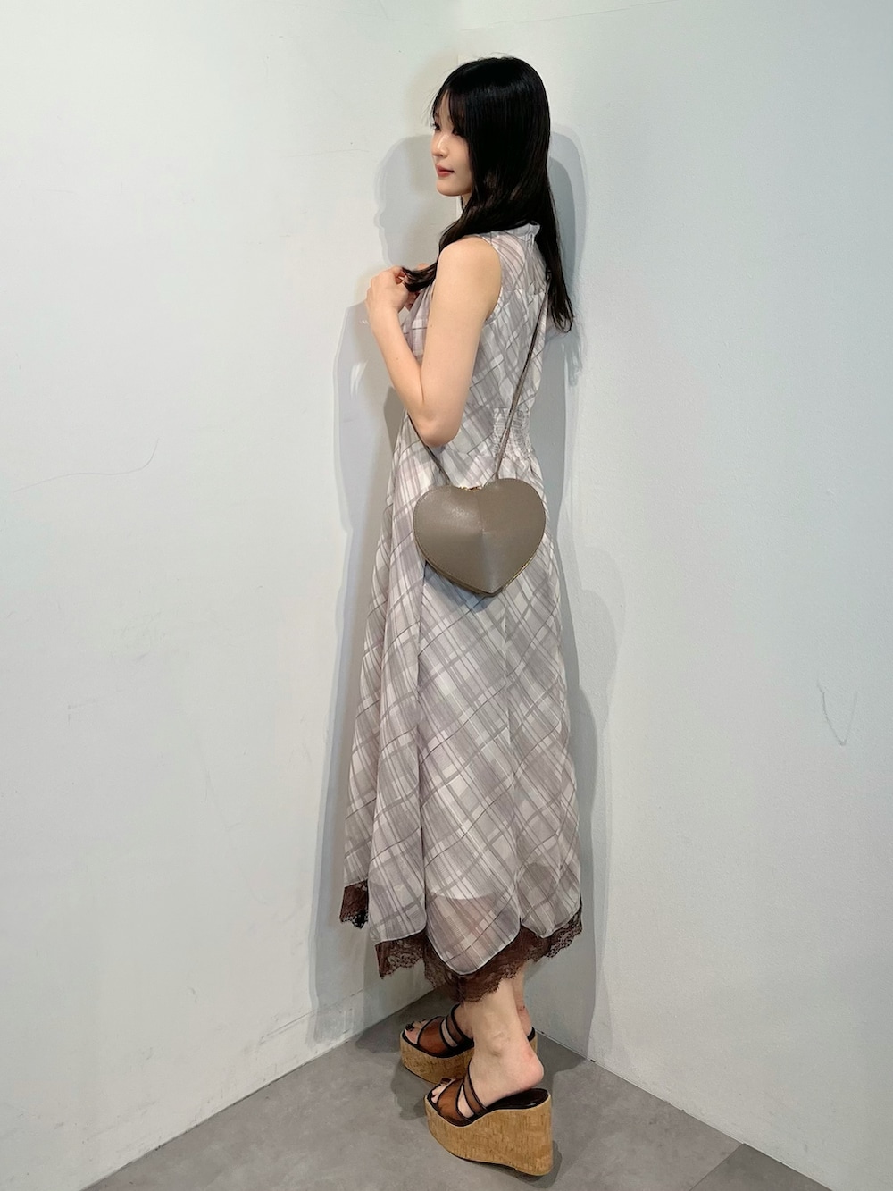 ベージュ系のワンピース、ブラウン系のサンダル、ベージュ系のショルダーバッグを着用したレディースの夏コーディネートの3枚目の写真