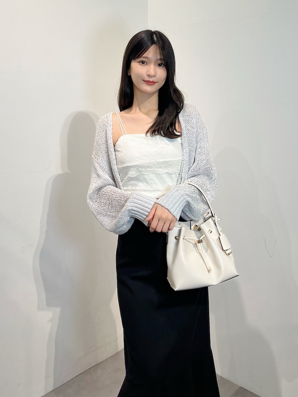 グレー系のカーディガン/ボレロ、ホワイト系のTシャツ/カットソー、ブラック系のスカートを着用したレディースの夏コーディネートの6枚目の写真