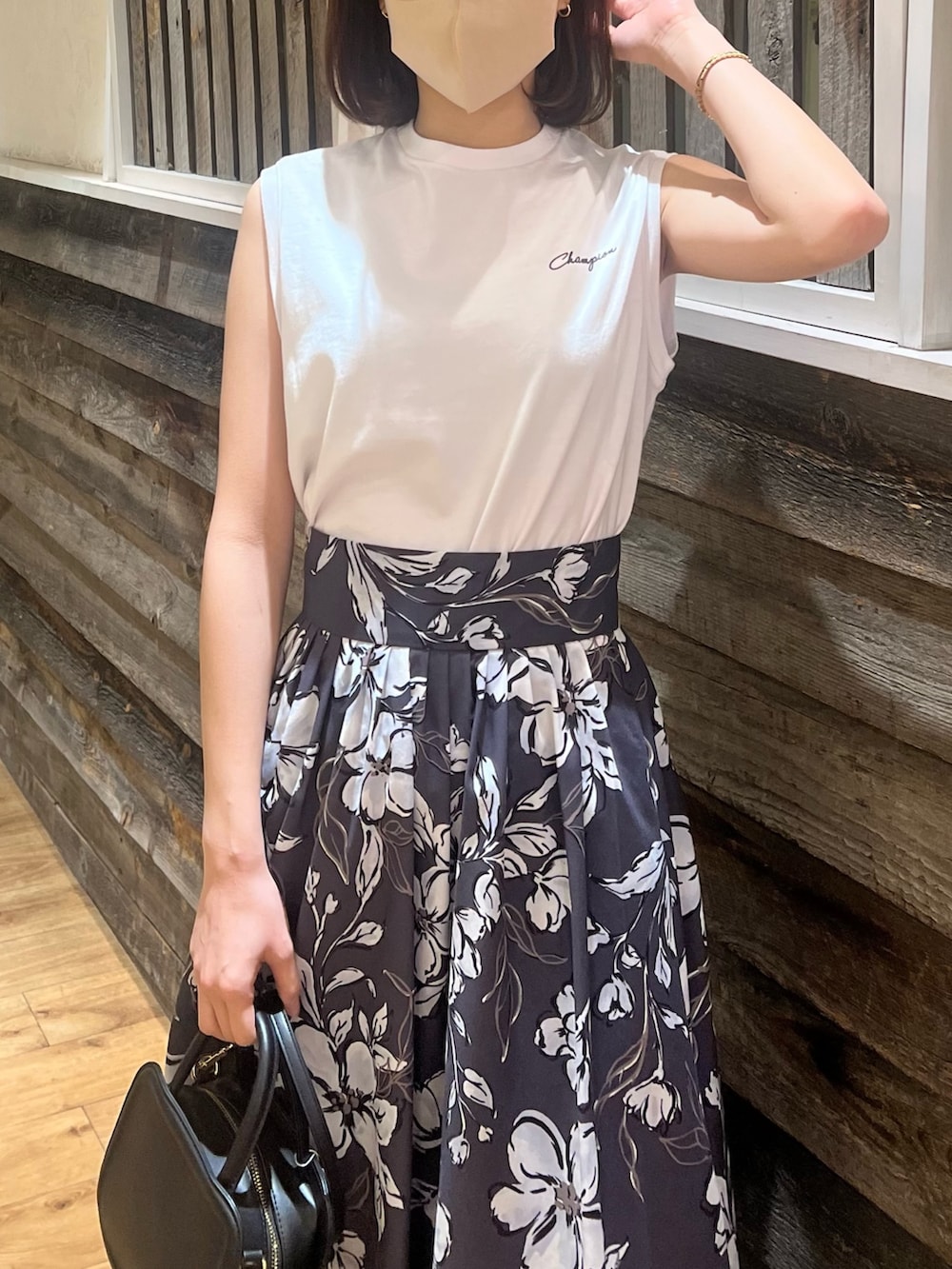 パープル系のスカート、ブラック系のハンドバッグ、ブラック系のサンダルを着用したレディースの春コーディネートの5枚目の写真