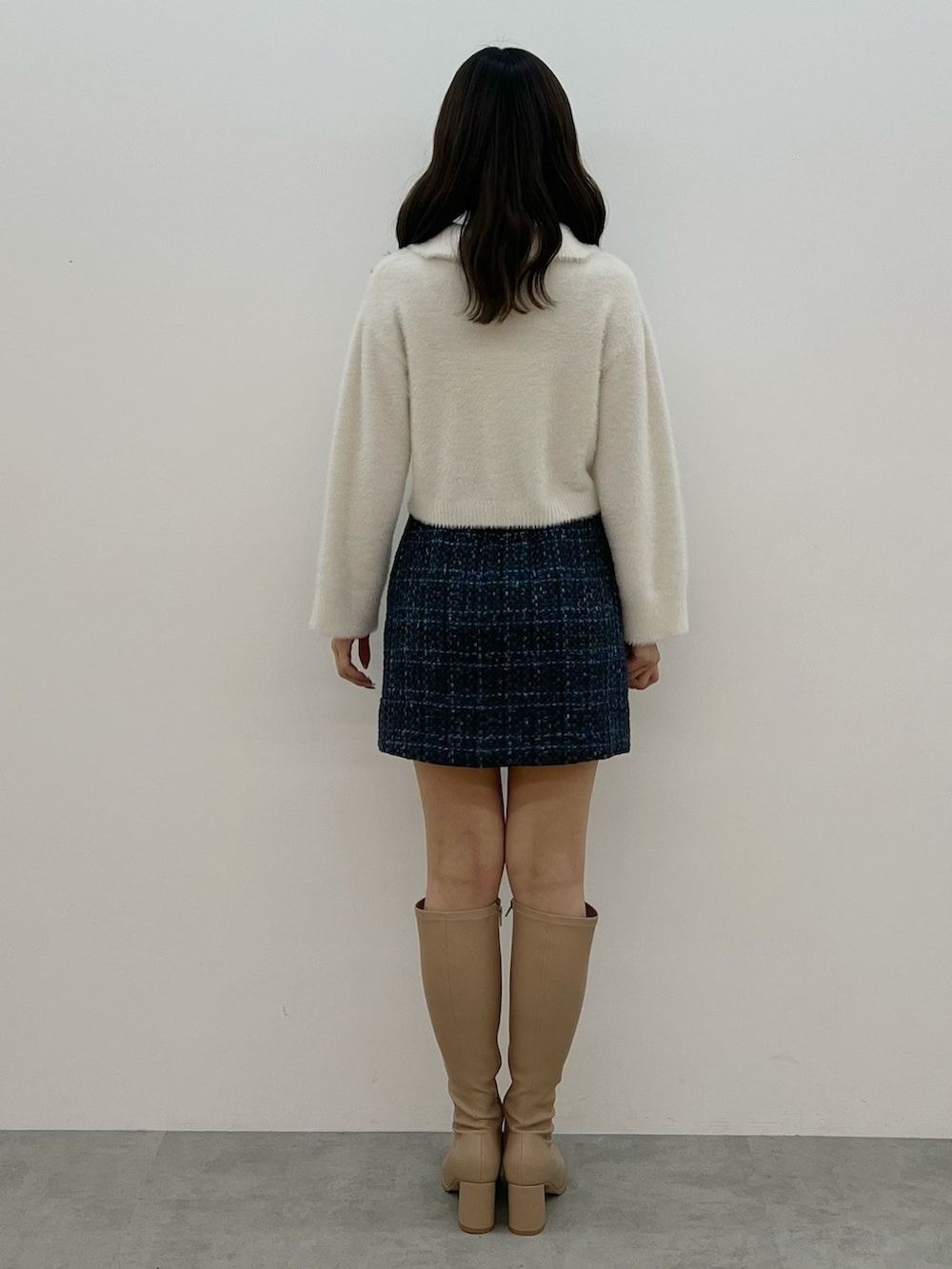 ホワイト系のニット/セーター、ブラック系のスカート、ベージュ系のブーツを着用したレディースの秋コーディネートの7枚目の写真