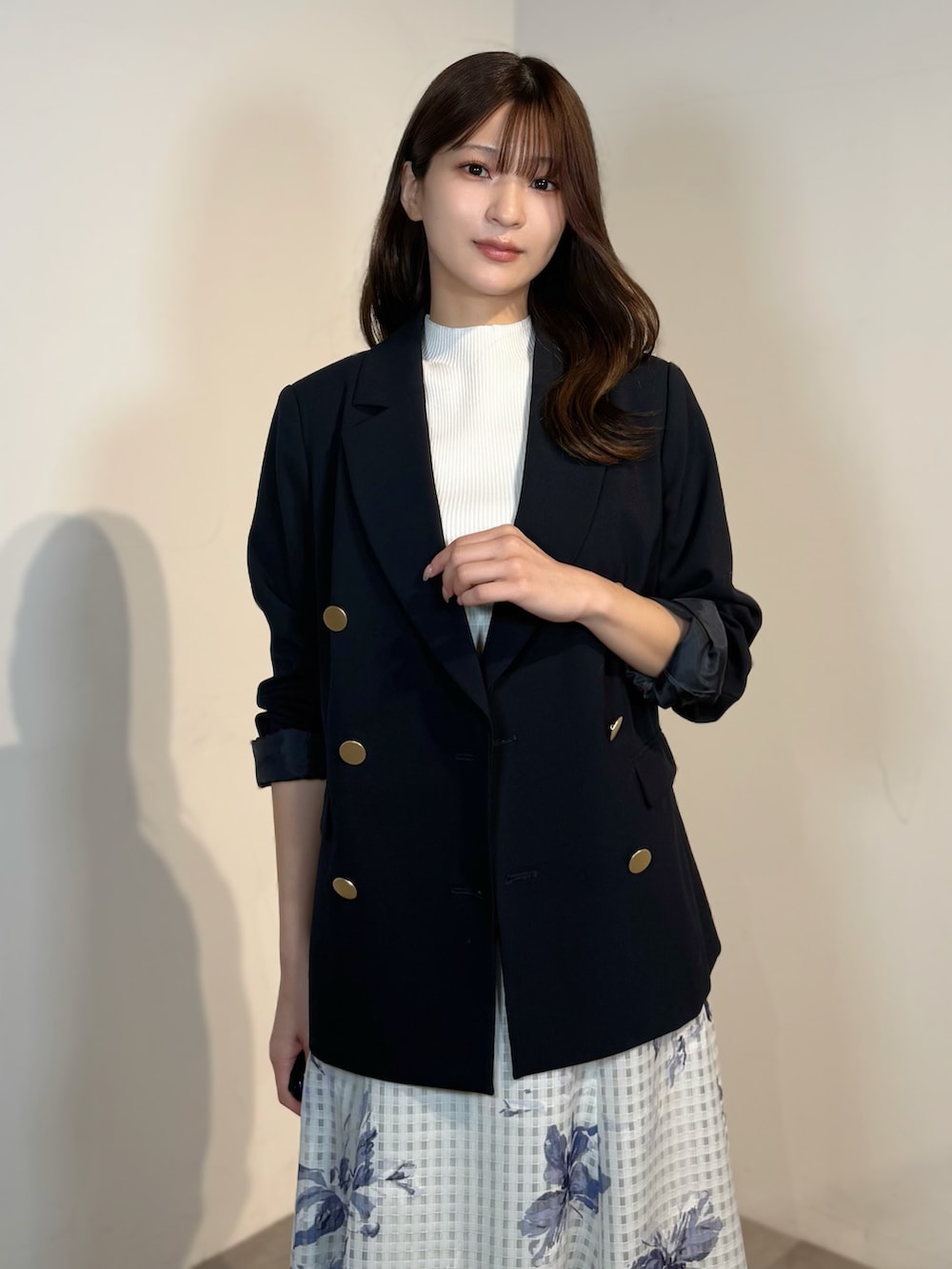 ホワイト系のニット/セーター、ブルー系のテーラードジャケット、ブルー系のスカートを着用したレディースの春コーディネートの2枚目の写真