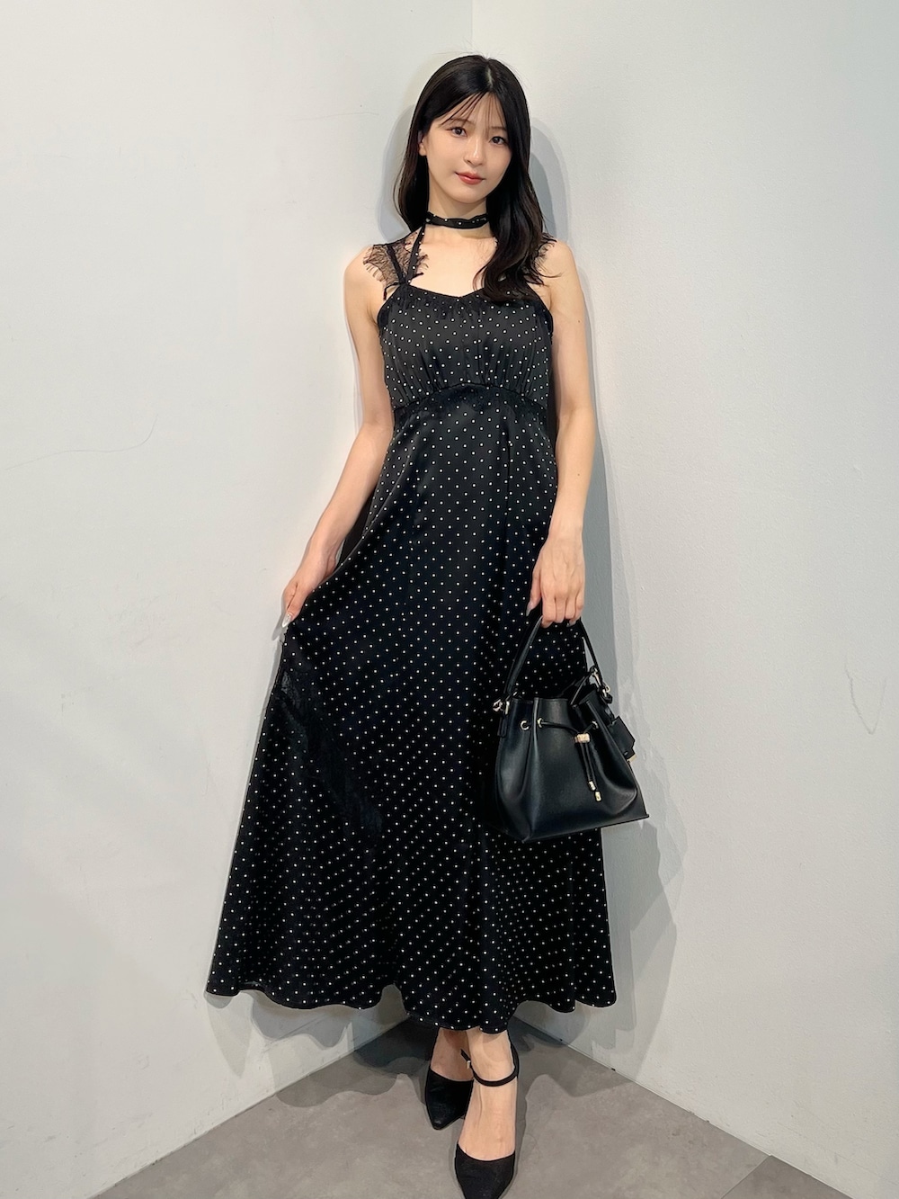 ブラック系のワンピース、ブラック系のショルダーバッグ、ブラック系のパンプスを着用したレディースの夏コーディネートの6枚目の写真