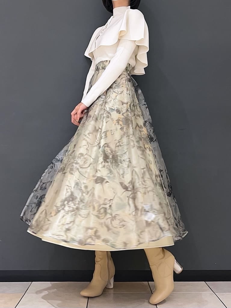 ベージュ系のブーツ、グリーン系のスカート、ホワイト系のニット/セーターを着用したレディースの秋コーディネートの2枚目の写真