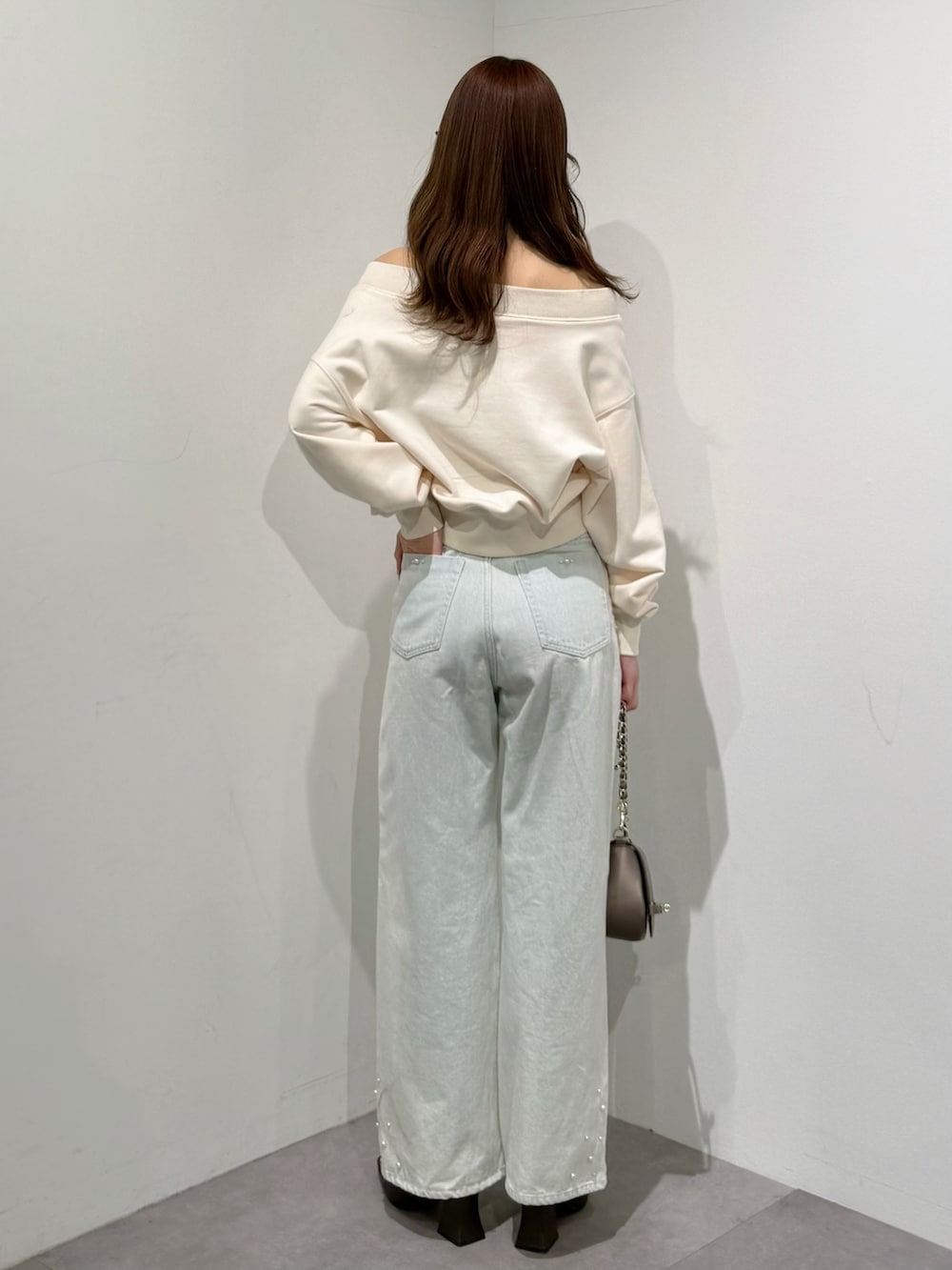 ブラウン系のパンプス、ブルー系のデニムパンツ、ブラウン系のハンドバッグを着用したレディースの春コーディネートの5枚目の写真