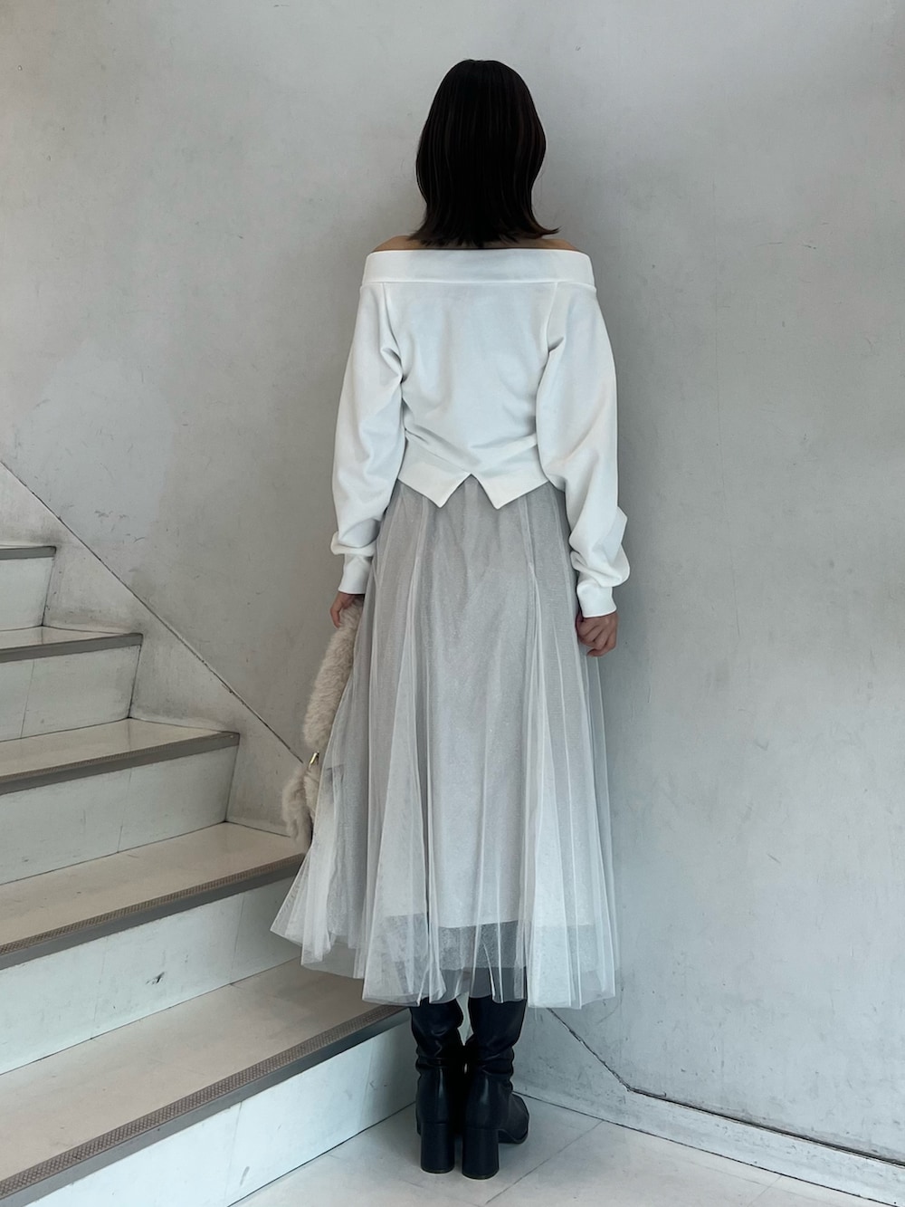 ブラウン系のショルダーバッグ、ホワイト系のスカート、ブラウン系のブーツを着用したレディースの秋コーディネートの9枚目の写真