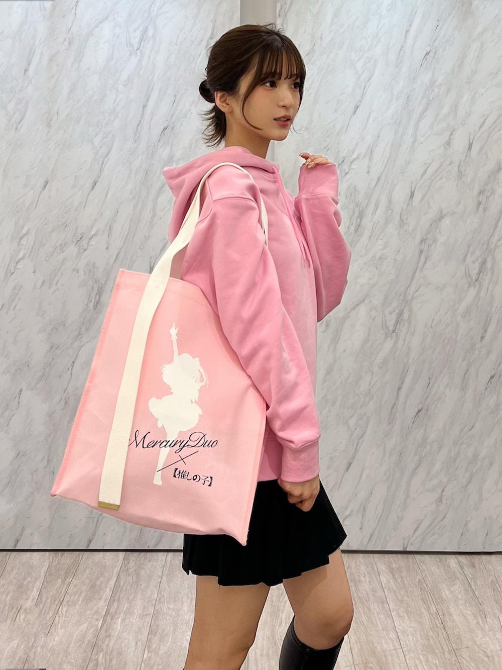 ピンク系のパーカー、ピンク系のトートバッグ、ブラック系のその他パンツを着用したレディースの秋コーディネートの2枚目の写真