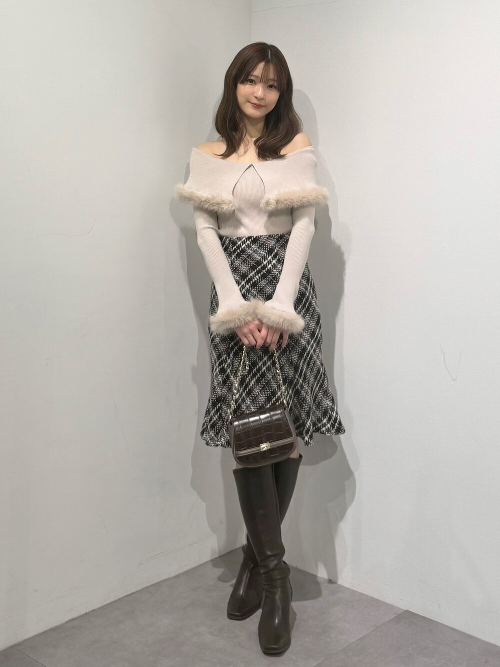 ベージュ系のニット/セーター、ブラック系のスカート、ブラウン系のブーツを着用したレディースの冬コーディネートの6枚目の写真