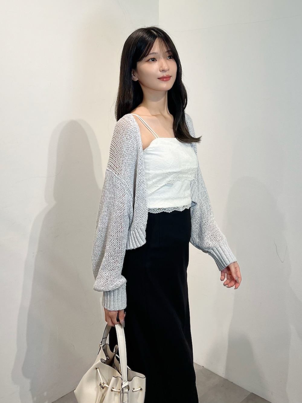 グレー系のカーディガン/ボレロ、ホワイト系のTシャツ/カットソー、ブラック系のスカートを着用したレディースの夏コーディネートの2枚目の写真