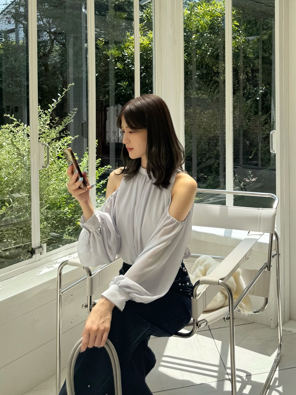 ブルー系のデニムパンツ、グレー系のパンプス、グレー系のシャツ/ブラウスを着用したレディースの秋コーディネートの10枚目の写真