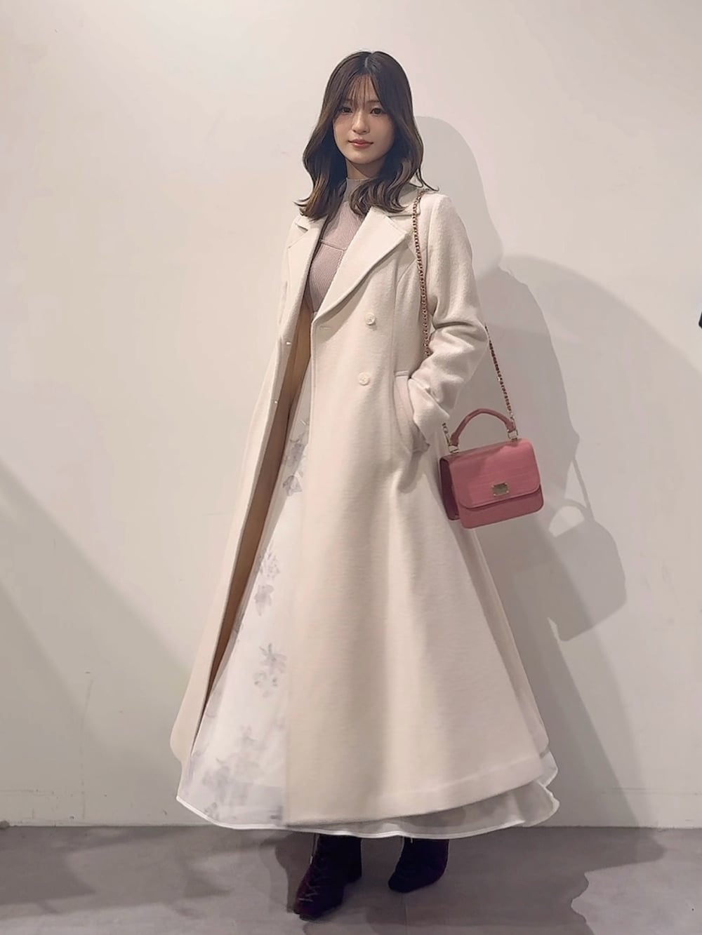 ホワイト系のその他アウター、ピンク系のハンドバッグ、ブラウン系のブーツを着用したレディースの秋コーディネートの3枚目の写真