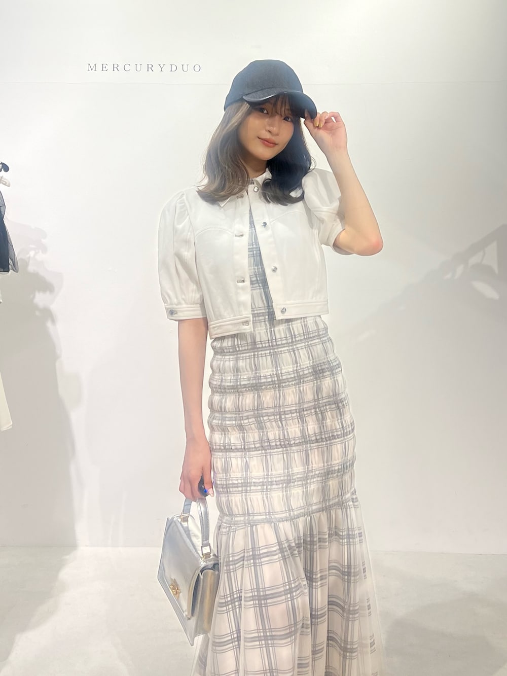 ブラック系のサンダル、ホワイト系のデニムジャケット、ホワイト系のワンピースを着用したレディースの春コーディネートの6枚目の写真