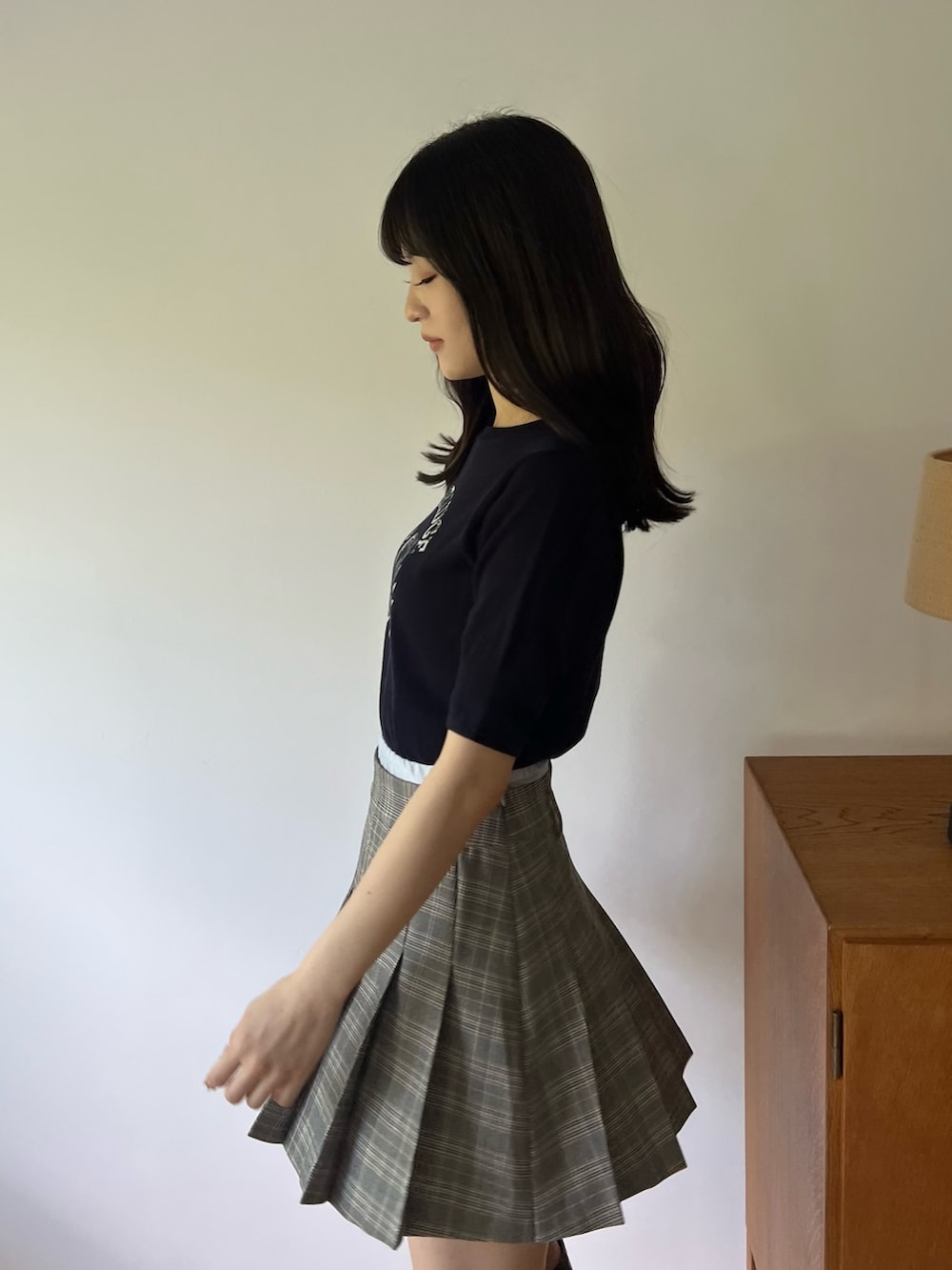 ブルー系のニット/セーター、グレー系のスカート、ブラック系のブーツを着用したレディースの夏コーディネートの4枚目の写真