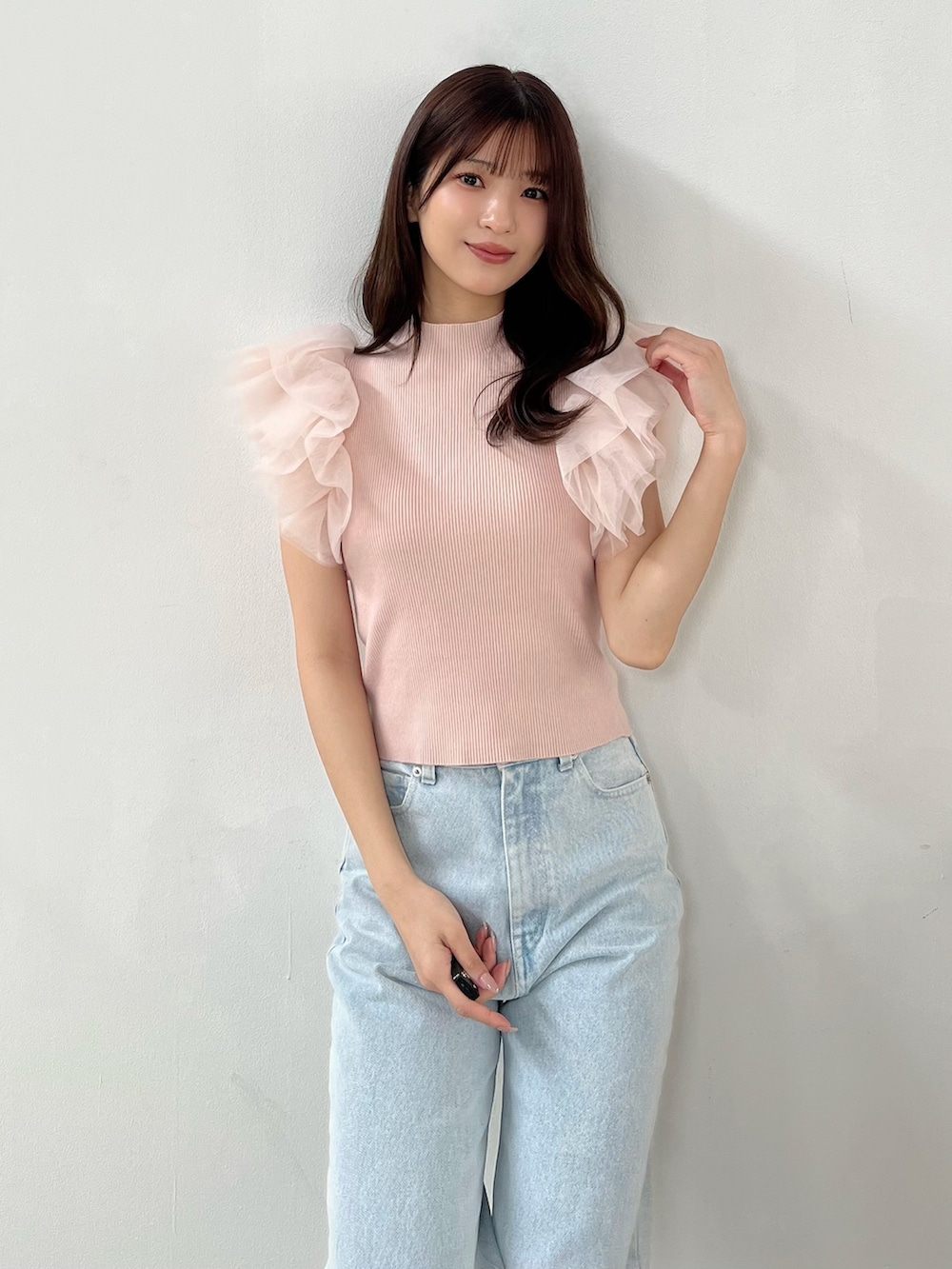 ピンク系のニット/セーター、ブルー系のデニムパンツ、その他のサンダルを着用したレディースの春コーディネートの3枚目の写真