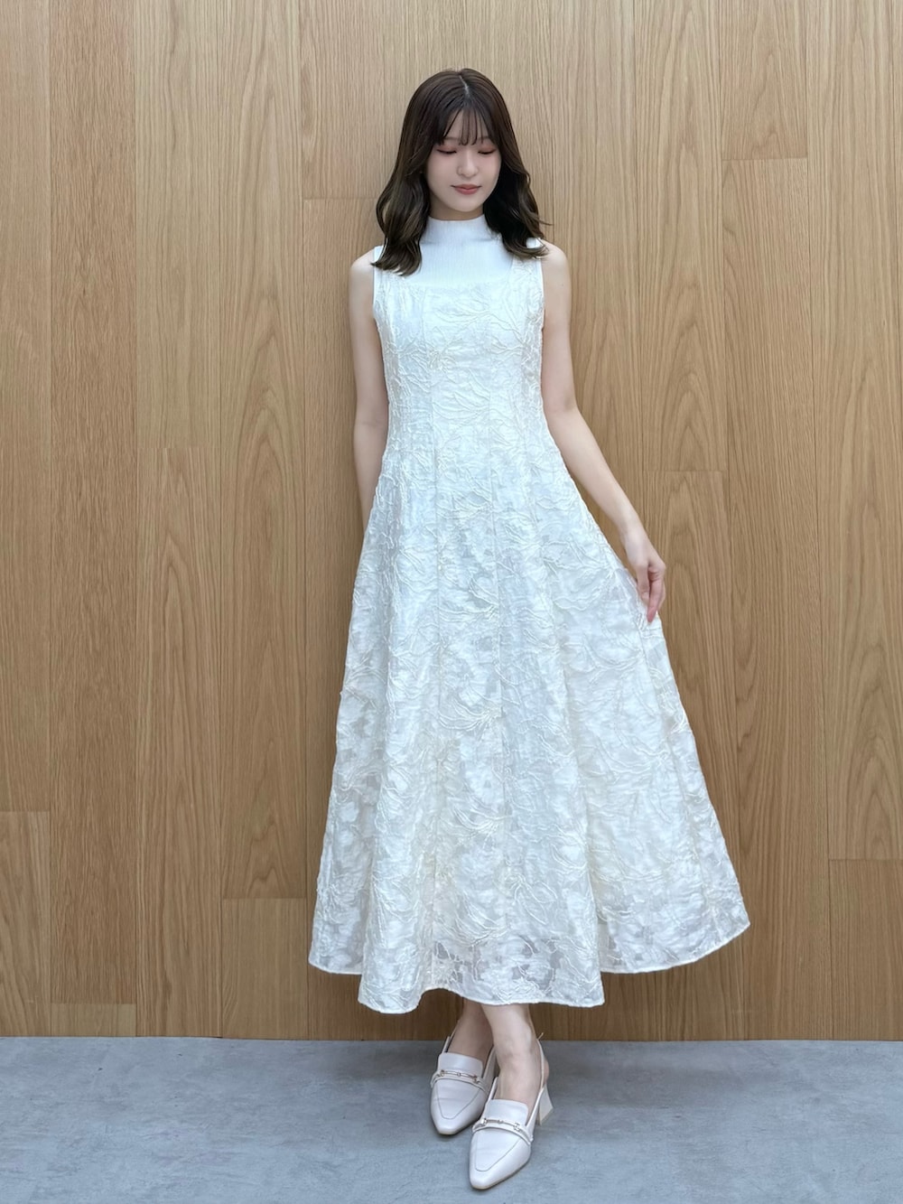 ホワイト系のワンピース、ホワイト系のニット/セーター、ホワイト系のパンプスを着用したレディースの冬コーディネートの6枚目の写真