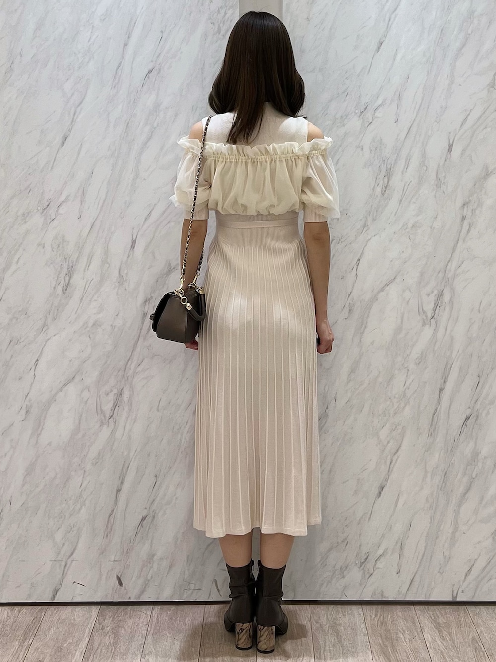 ホワイト系のワンピース、ブラウン系のブーツ、ブラウン系のハンドバッグを着用したレディースの春コーディネートの4枚目の写真