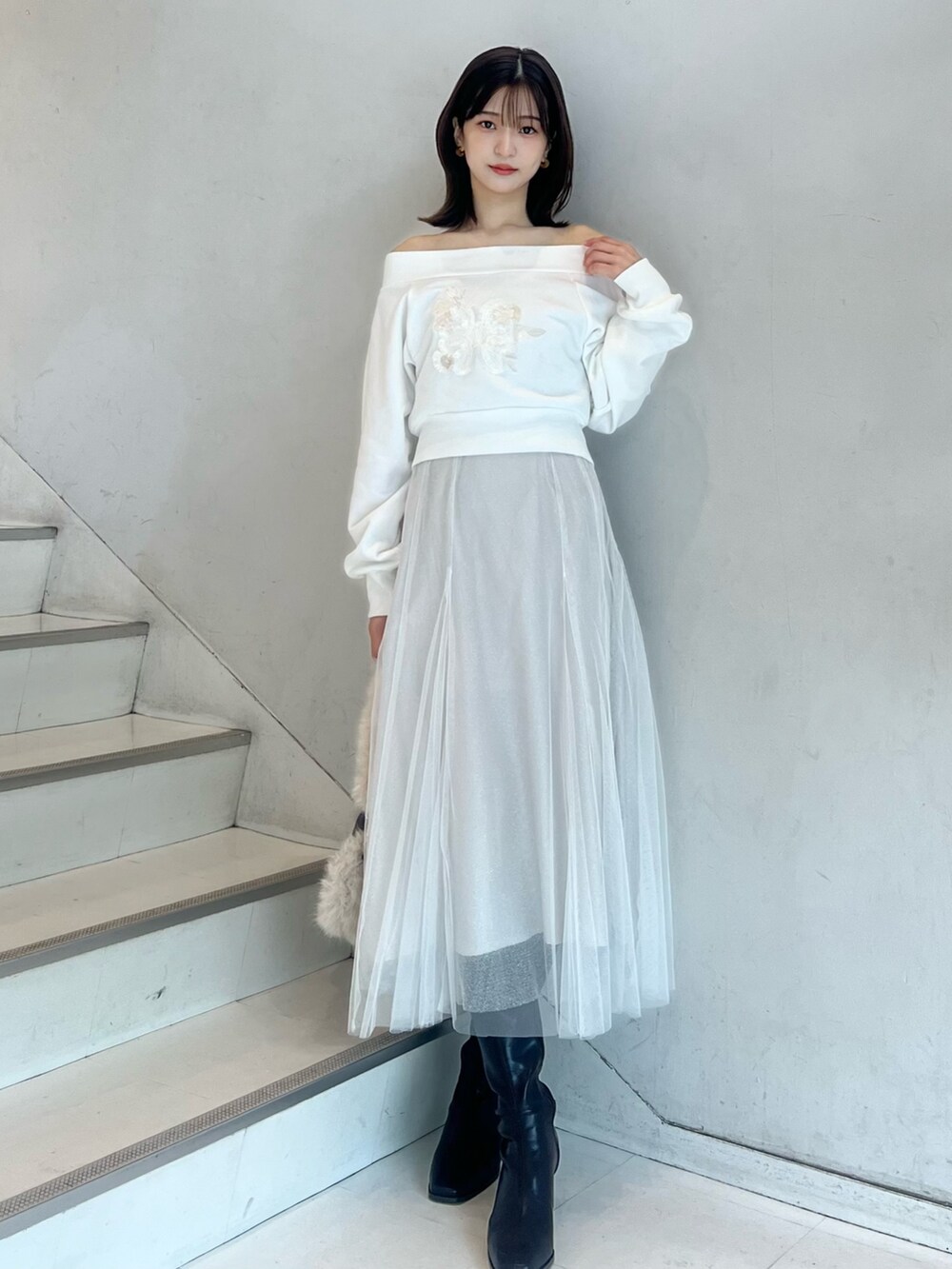 ブラウン系のショルダーバッグ、ホワイト系のスカート、ブラウン系のブーツを着用したレディースの秋コーディネートの3枚目の写真