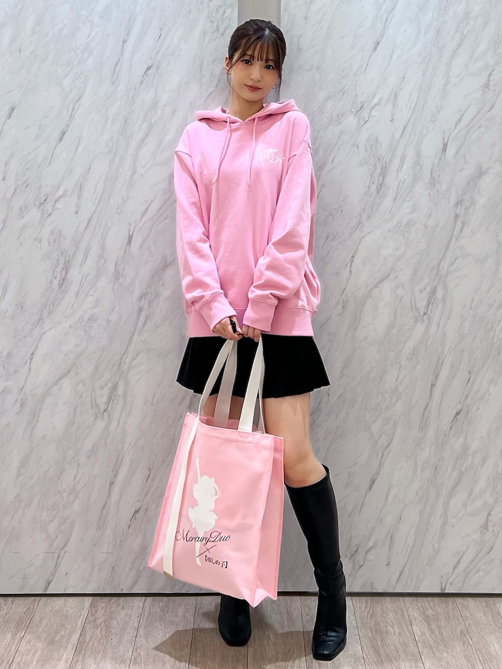 ピンク系のパーカー、ピンク系のトートバッグ、ブラック系のその他パンツを着用したレディースの秋コーディネートの3枚目の写真