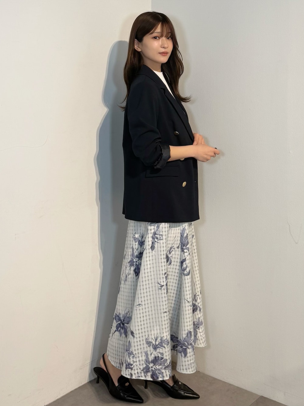 ホワイト系のニット/セーター、ブルー系のテーラードジャケット、ブルー系のスカートを着用したレディースの春コーディネートの3枚目の写真