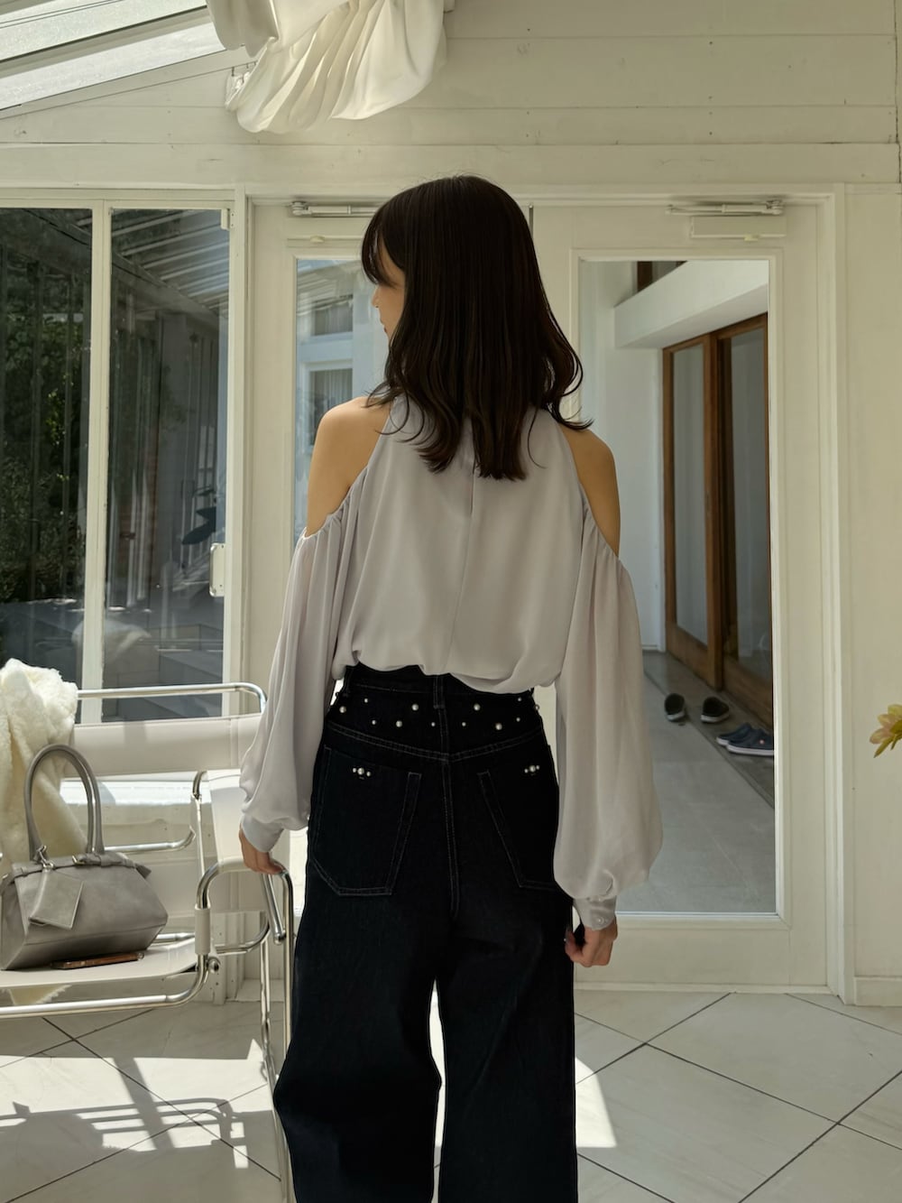ブルー系のデニムパンツ、グレー系のパンプス、グレー系のシャツ/ブラウスを着用したレディースの秋コーディネートの9枚目の写真