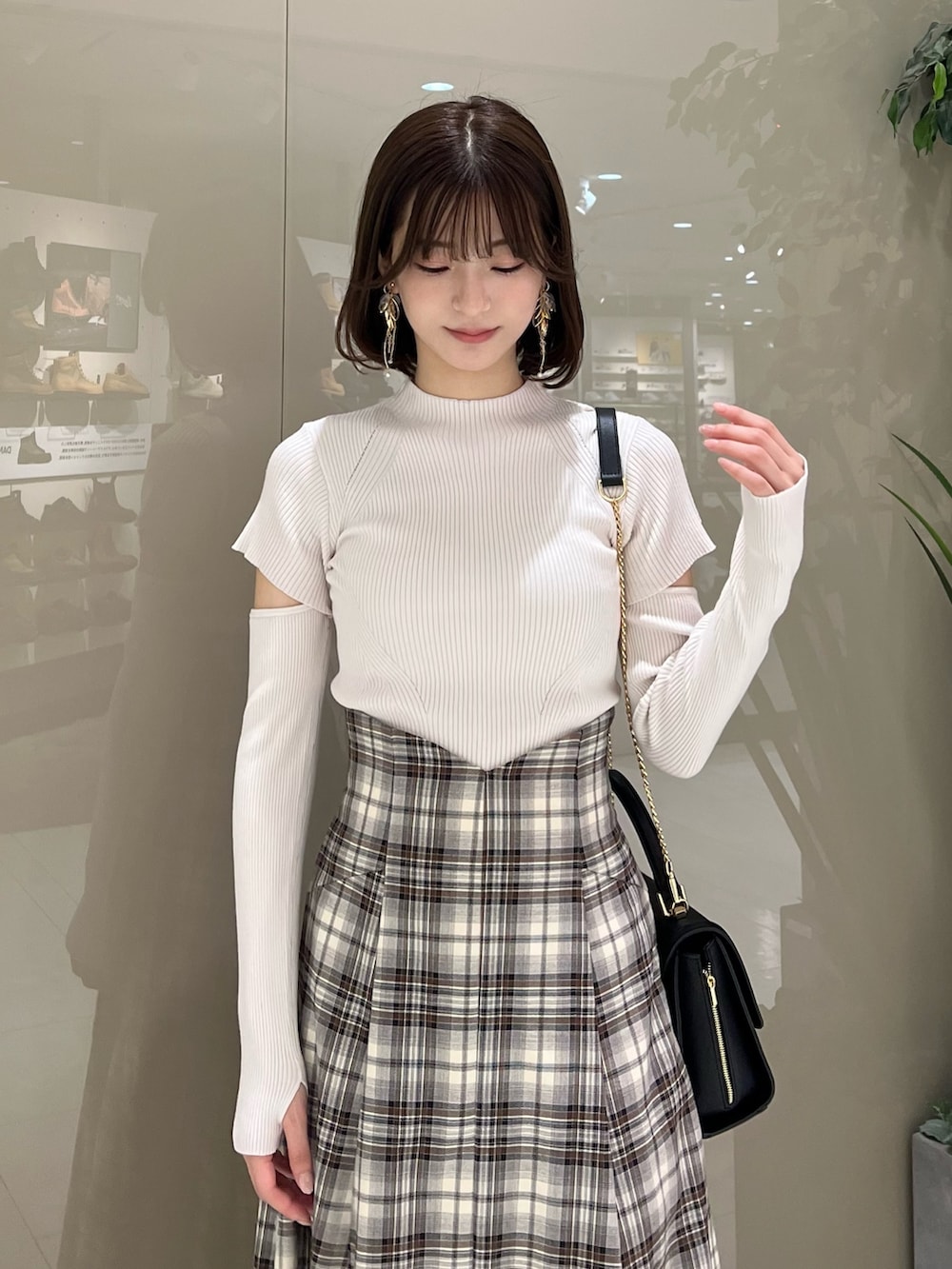 ホワイト系のニット/セーター、ブラウン系のテーラードジャケット、ブラウン系のスカートを着用したレディースの秋コーディネートの10枚目の写真