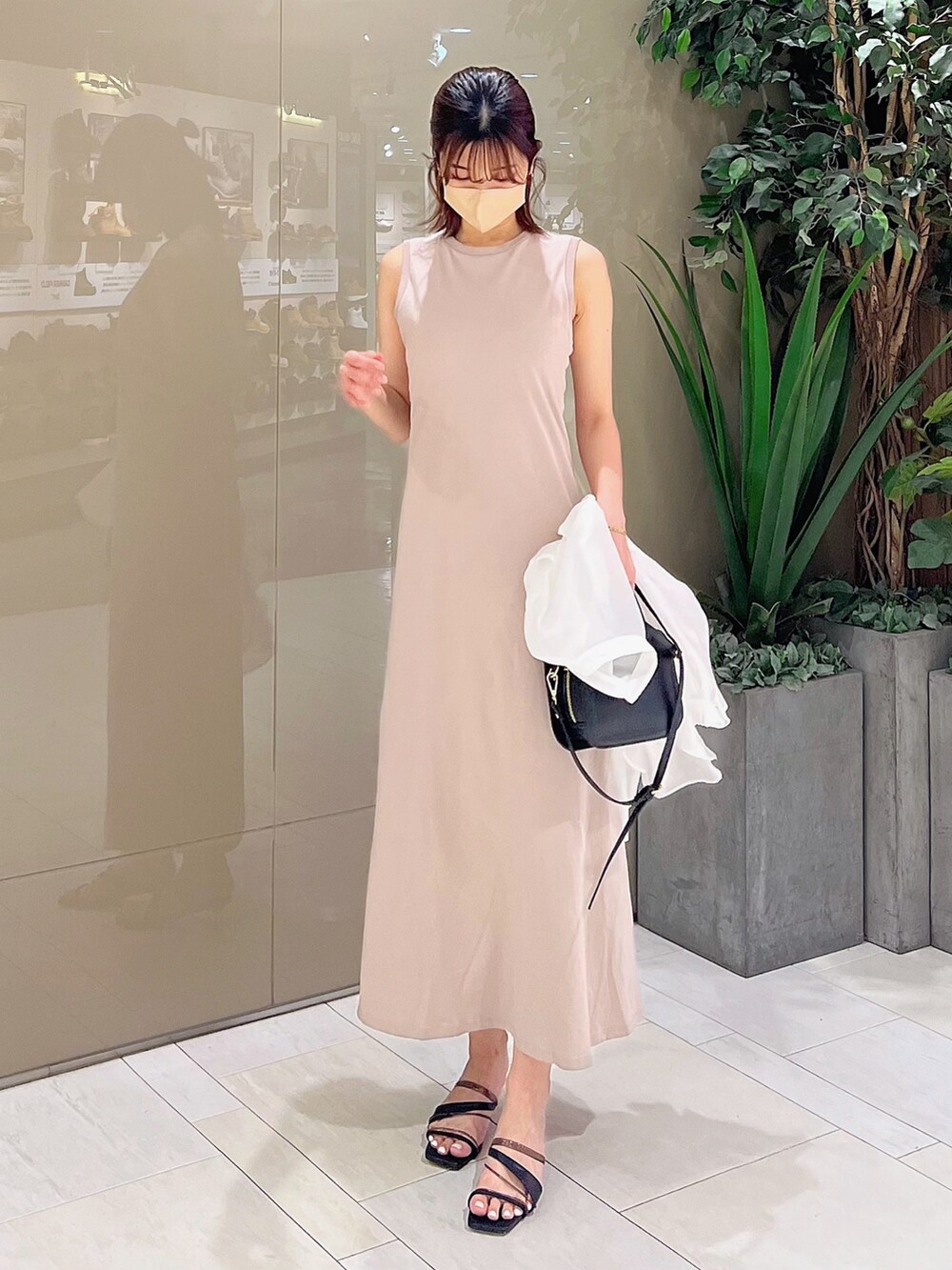 ベージュ系のワンピース、ブラック系のハンドバッグ、ブラック系のサンダルを着用したレディースの春コーディネートの6枚目の写真