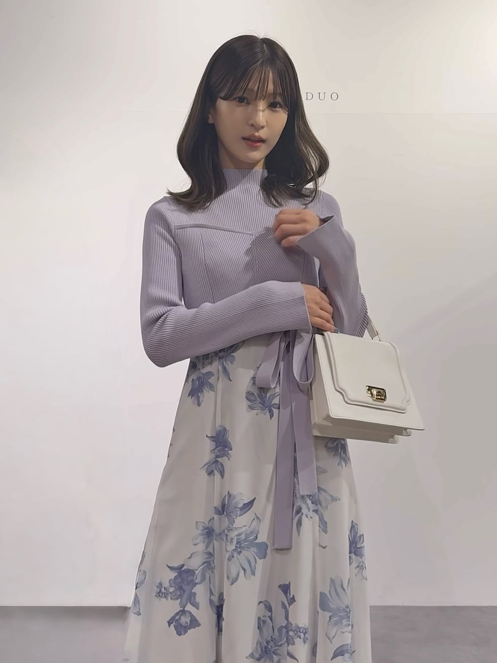 パープル系のワンピース、ブラウン系のブーツ、ホワイト系のハンドバッグを着用したレディースの秋コーディネートの10枚目の写真