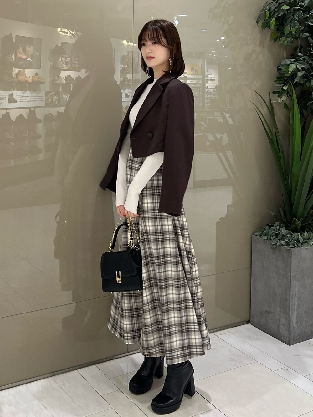 ホワイト系のニット/セーター、ブラウン系のテーラードジャケット、ブラウン系のスカートを着用したレディースの秋コーディネートの2枚目の写真