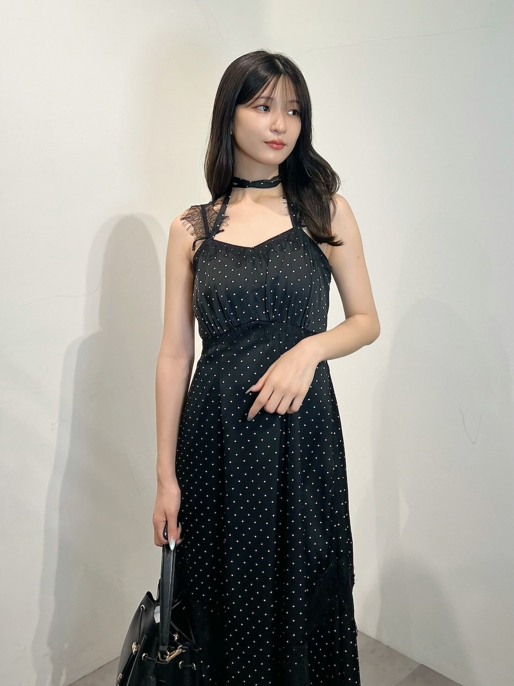 ブラック系のワンピース、ブラック系のショルダーバッグ、ブラック系のパンプスを着用したレディースの夏コーディネートの3枚目の写真