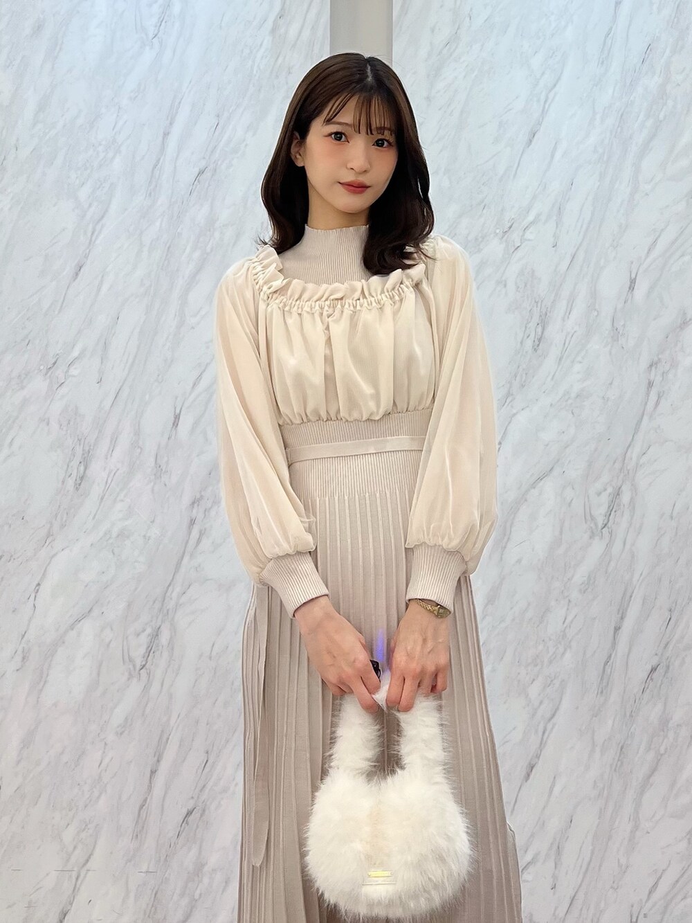 ホワイト系のワンピース、ホワイト系のハンドバッグ、ホワイト系のパンプスを着用したレディースの冬コーディネートの3枚目の写真