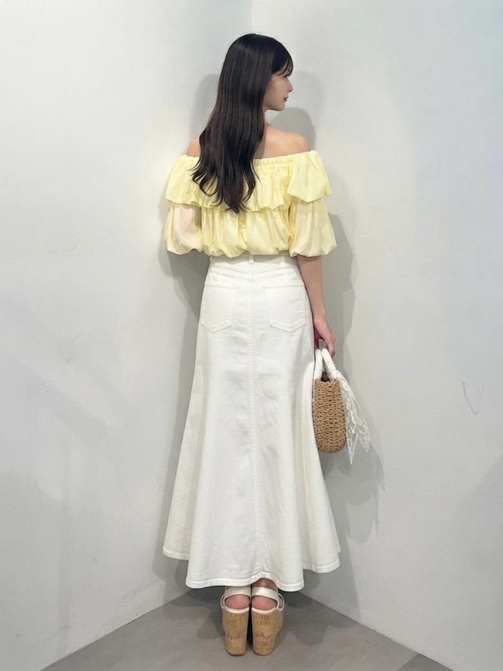 イエロー系のシャツ/ブラウス、ホワイト系のスカート、ホワイト系のサンダルを着用したレディースの夏コーディネートの5枚目の写真
