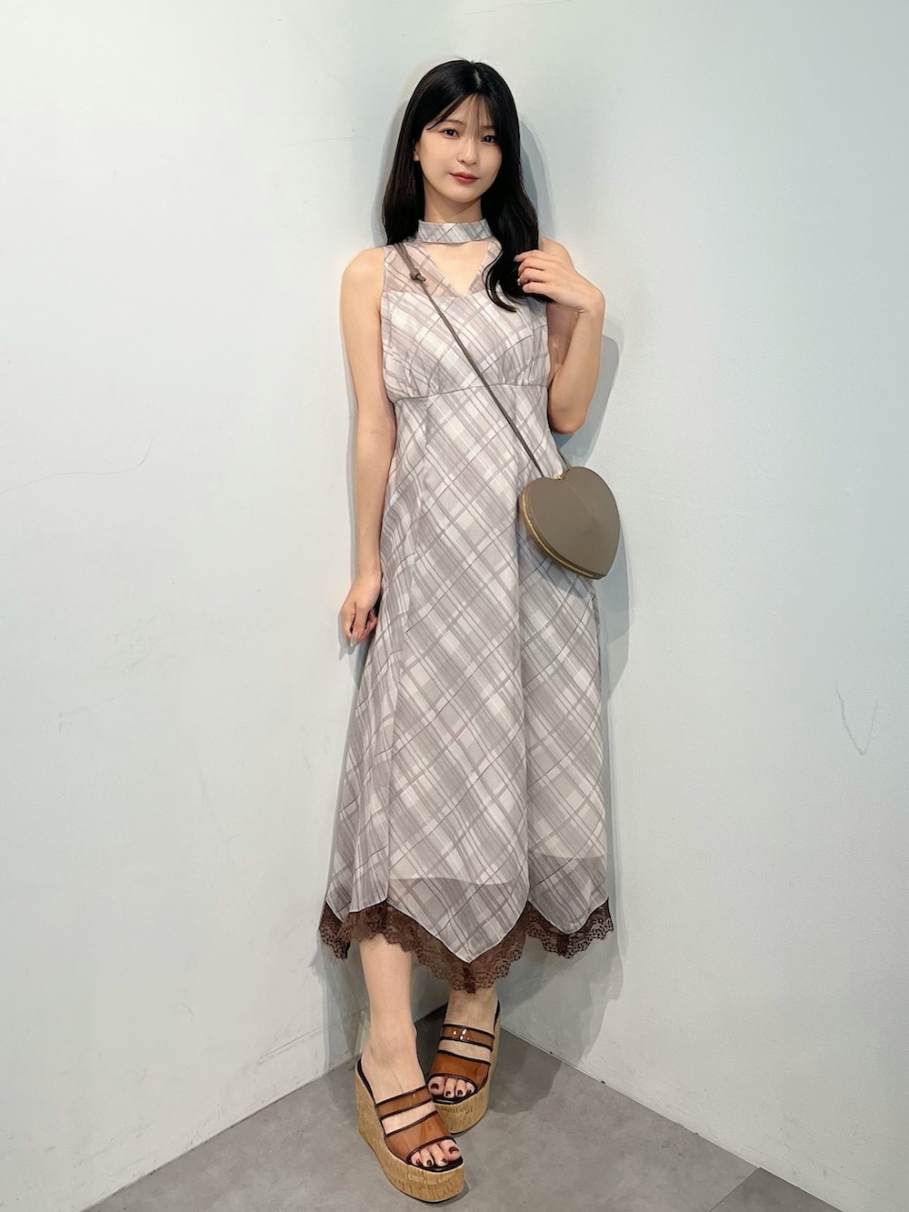 ベージュ系のワンピース、ブラウン系のサンダル、ベージュ系のショルダーバッグを着用したレディースの夏コーディネートの5枚目の写真