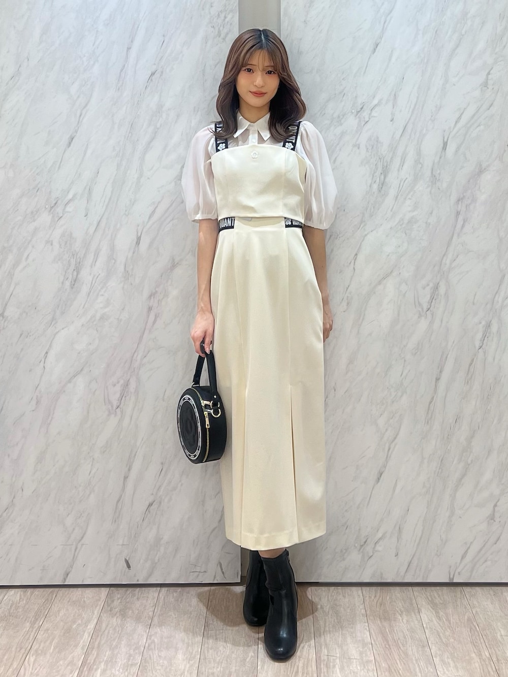 ホワイト系のシャツ/ブラウス、ホワイト系のスカート、ブラック系のショルダーバッグを着用したレディースの冬コーディネートの2枚目の写真