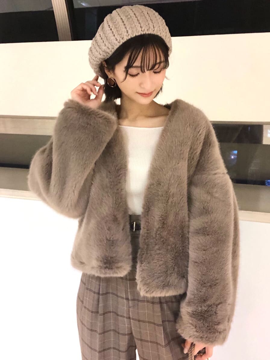 ブラウン系のその他アウター、ベージュ系のハンドバッグ、ホワイト系のニット/セーターを着用したレディースの秋コーディネートの4枚目の写真