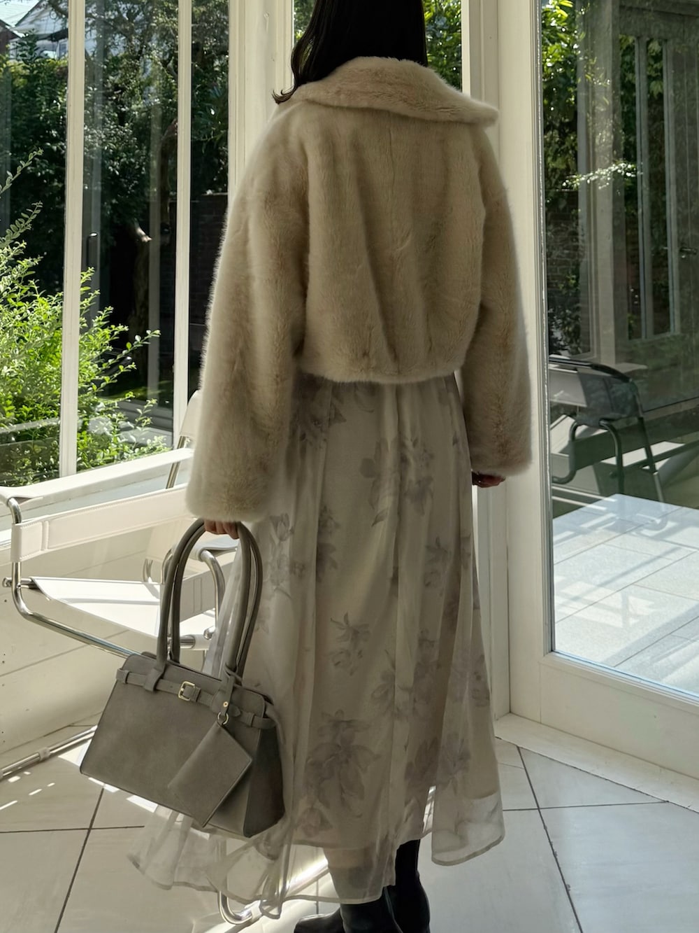 ベージュ系のワンピース、グレー系のハンドバッグ、ブラック系のブーツを着用したレディースの秋コーディネートの4枚目の写真