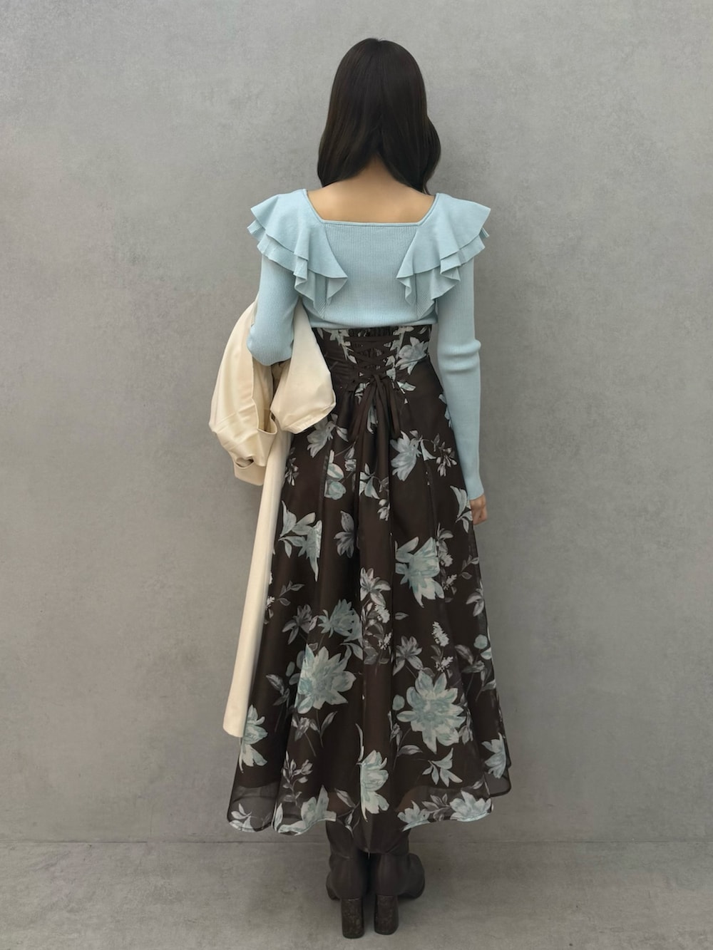 ブラウン系のブーツ、グリーン系のニット/セーター、ブラウン系のスカートを着用したレディースの春コーディネートの5枚目の写真