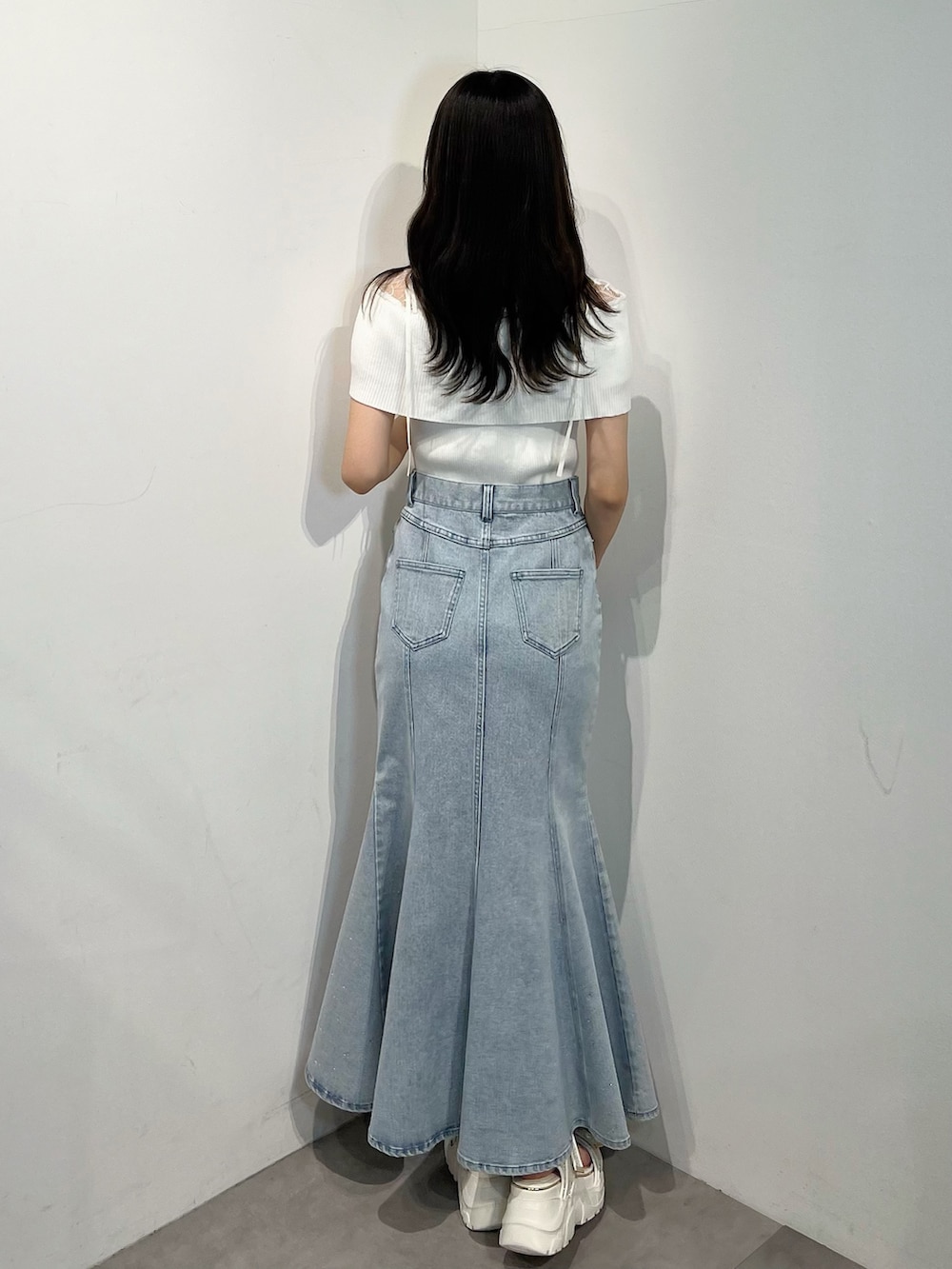 ホワイト系のニット/セーター、ブルー系のスカート、シルバー系のサンダルを着用したレディースの夏コーディネートの4枚目の写真