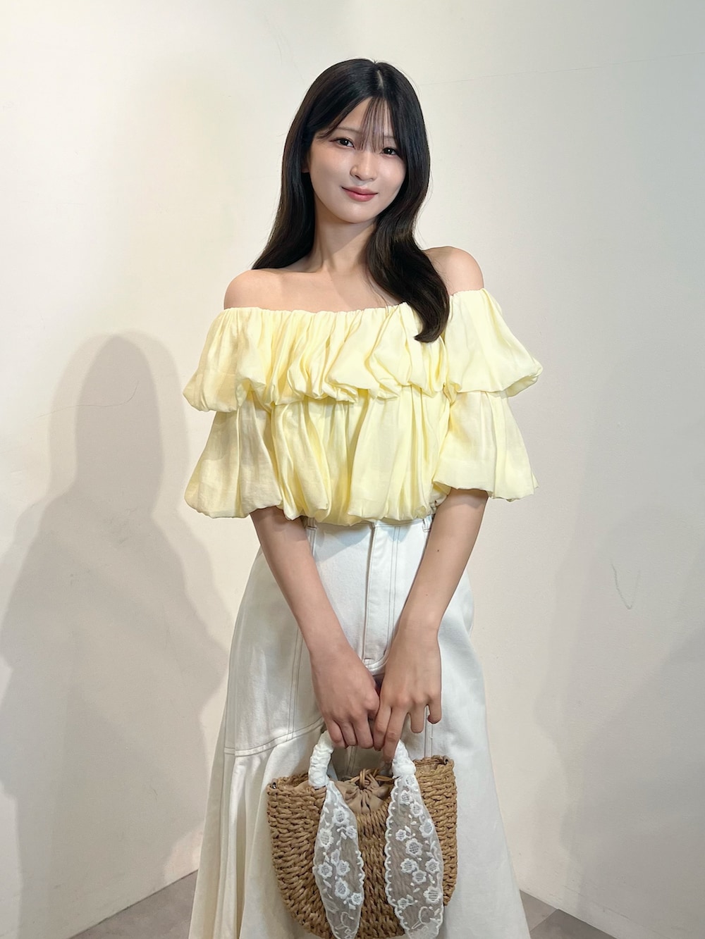 イエロー系のシャツ/ブラウス、ホワイト系のスカート、ホワイト系のサンダルを着用したレディースの夏コーディネートの2枚目の写真