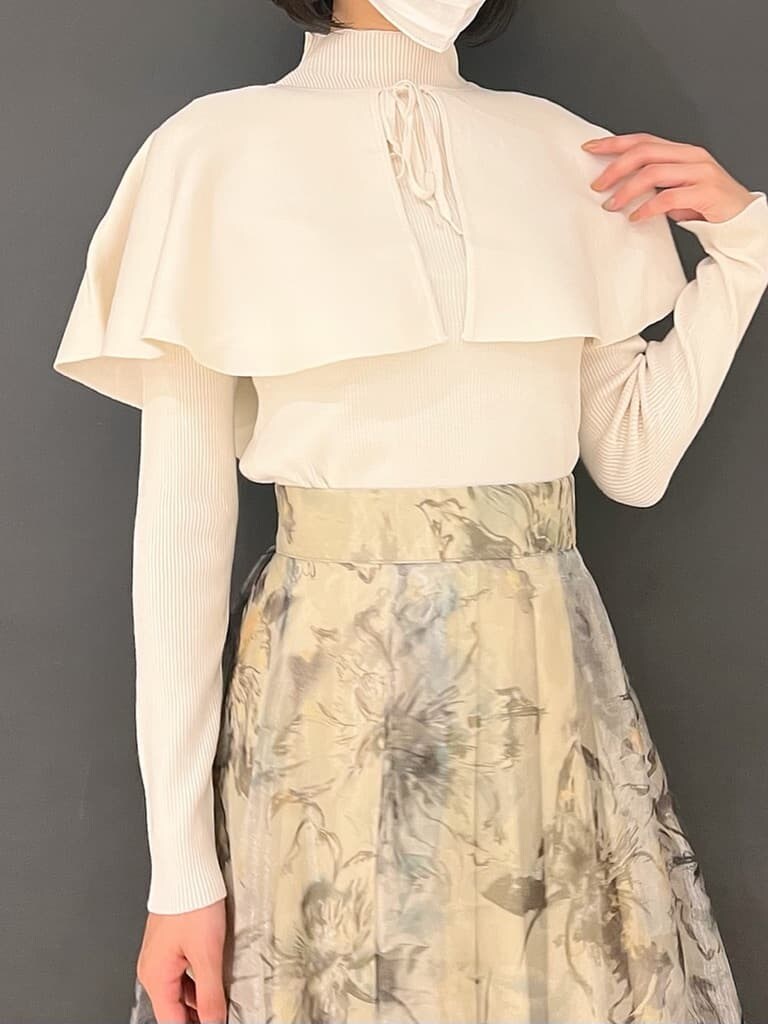 ベージュ系のブーツ、グリーン系のスカート、ホワイト系のニット/セーターを着用したレディースの秋コーディネートの5枚目の写真