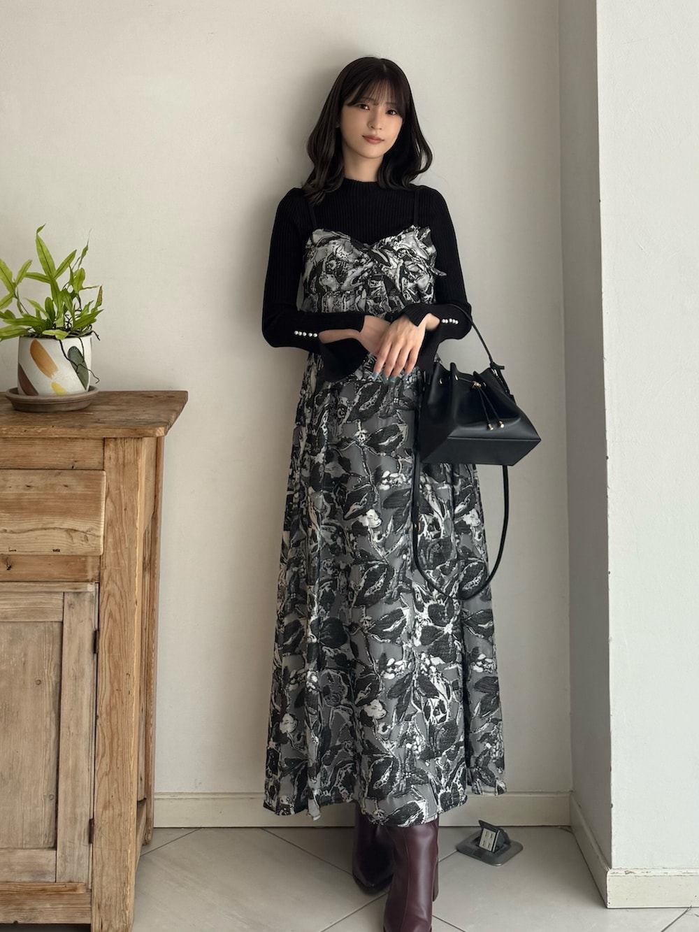 ブラック系のニット/セーター、ブラック系のワンピース、レッド系のブーツを着用したレディースの秋コーディネートの6枚目の写真