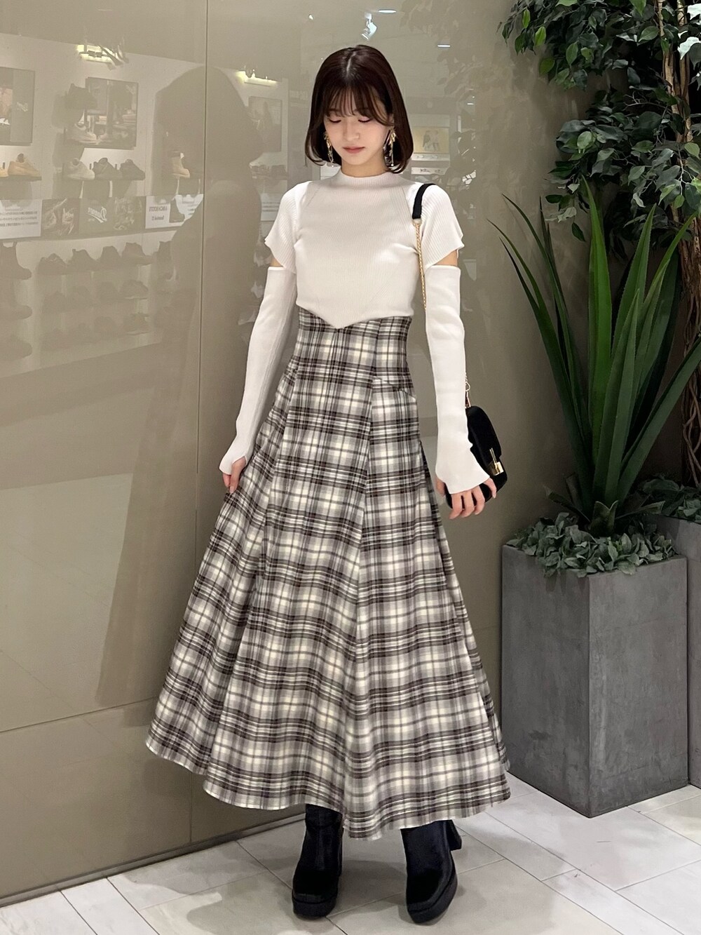 ホワイト系のニット/セーター、ブラウン系のテーラードジャケット、ブラウン系のスカートを着用したレディースの秋コーディネートの7枚目の写真