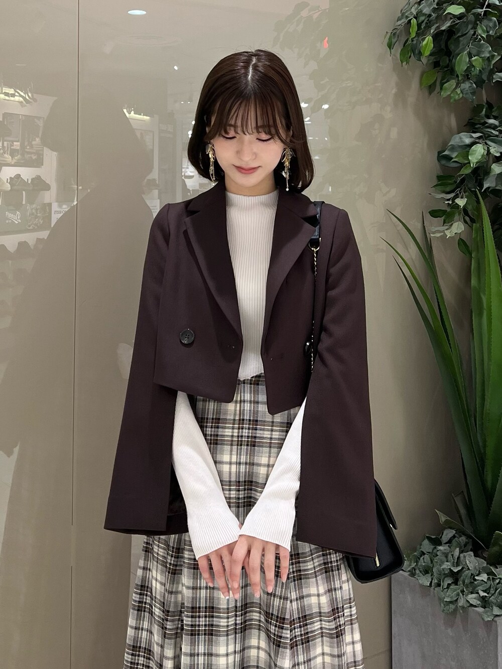 ホワイト系のニット/セーター、ブラウン系のテーラードジャケット、ブラウン系のスカートを着用したレディースの秋コーディネートの4枚目の写真