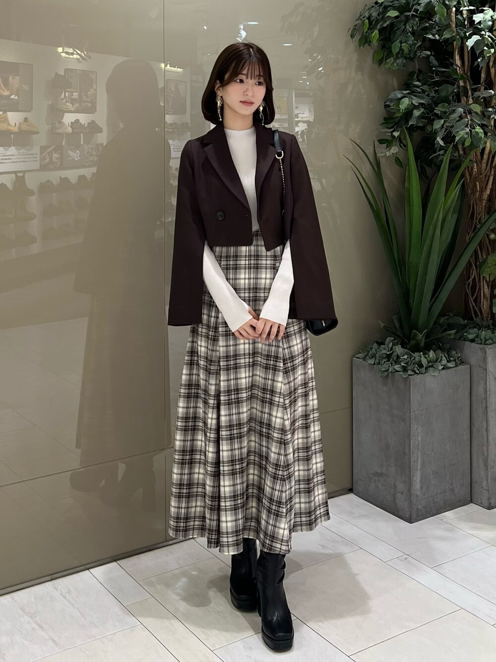 ホワイト系のニット/セーター、ブラウン系のテーラードジャケット、ブラウン系のスカートを着用したレディースの秋コーディネートの6枚目の写真