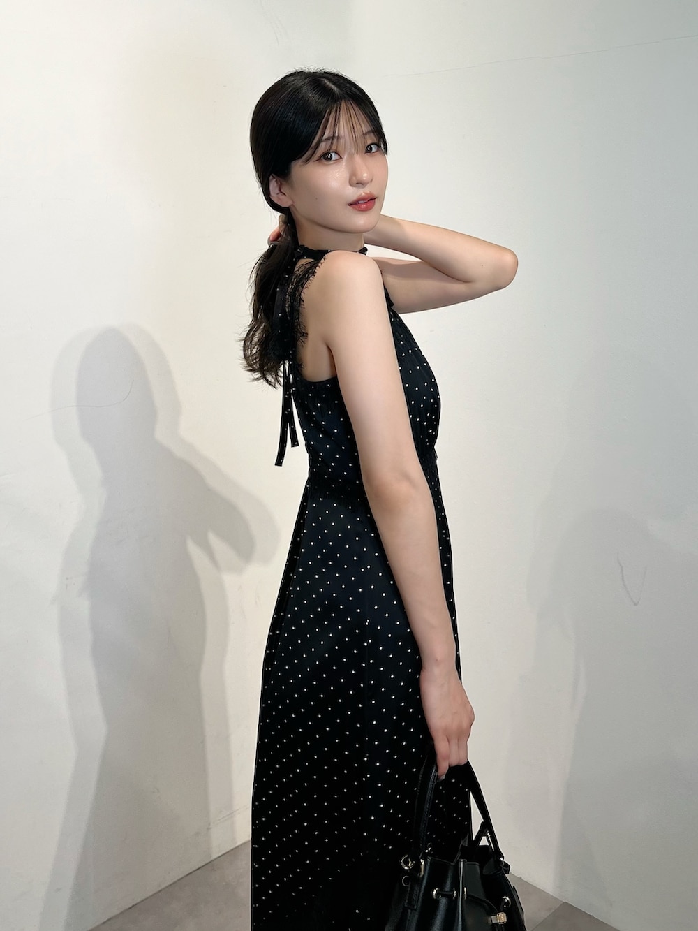ブラック系のワンピース、ブラック系のショルダーバッグ、ブラック系のパンプスを着用したレディースの夏コーディネートの5枚目の写真