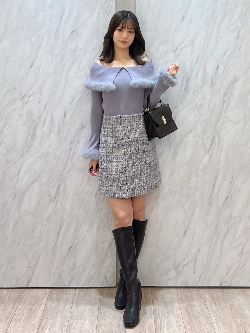 ブラウン系のブーツ、ブラウン系のハンドバッグ、ホワイト系のスカートを着用したレディースの冬コーディネートの5枚目の写真