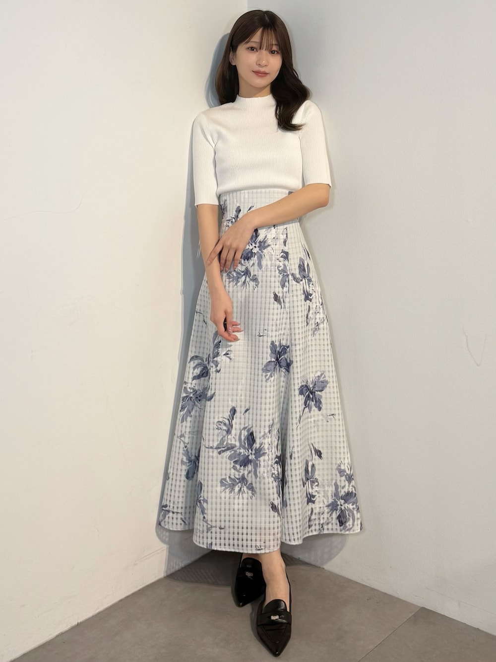 ホワイト系のニット/セーター、ブルー系のテーラードジャケット、ブルー系のスカートを着用したレディースの春コーディネートの6枚目の写真