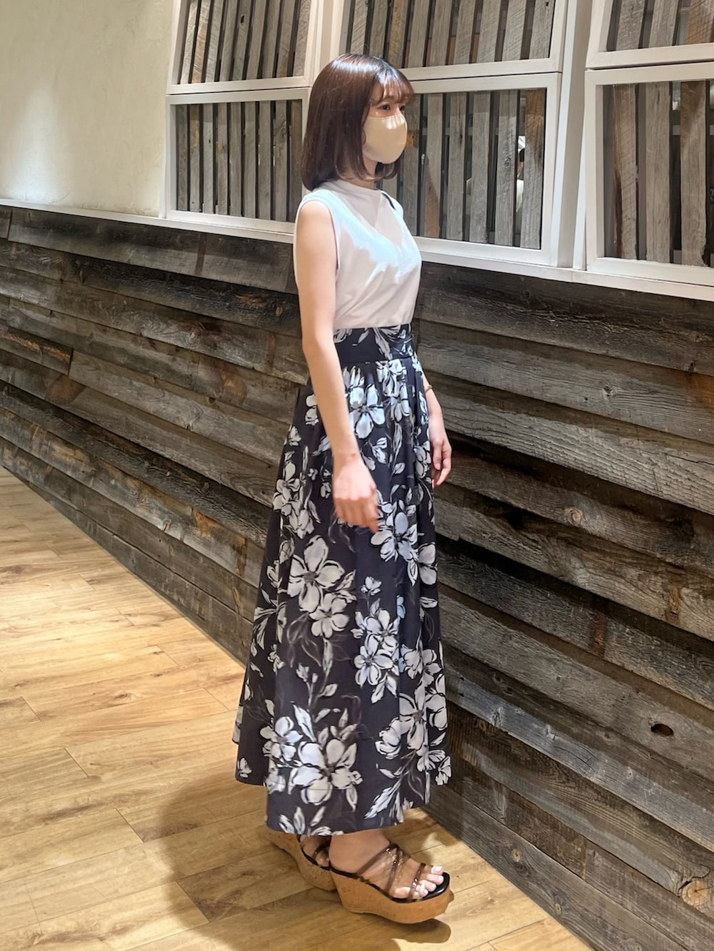 パープル系のスカート、ブラック系のハンドバッグ、ブラック系のサンダルを着用したレディースの春コーディネートの3枚目の写真