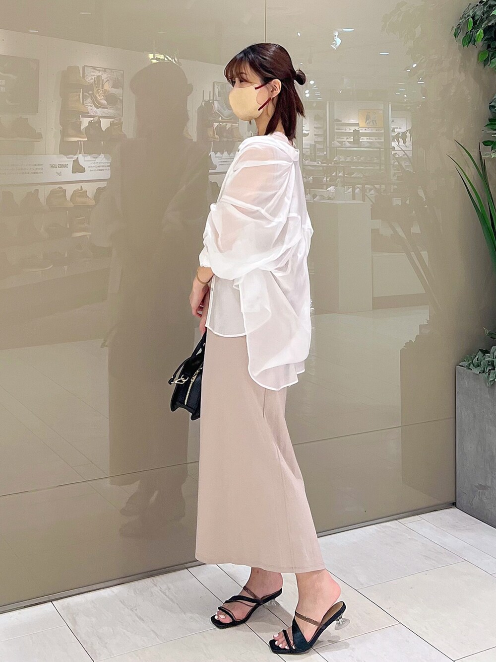 ベージュ系のワンピース、ブラック系のハンドバッグ、ブラック系のサンダルを着用したレディースの春コーディネートの3枚目の写真