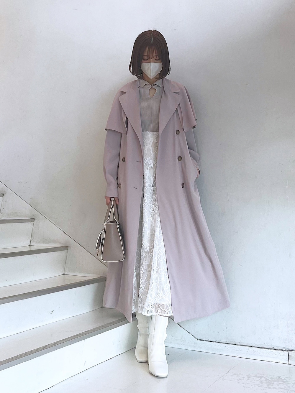 ベージュ系のハンドバッグ、ホワイト系のブーツ、ホワイト系のスカートを着用したレディースの冬コーディネートの5枚目の写真